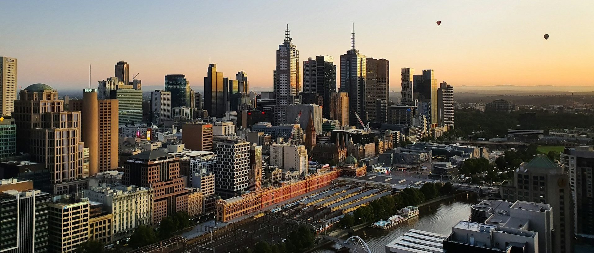 Melbourne skylight during sunset. There are two hot balloons in the background.